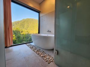 a bathroom with a tub and a large window at Taman Dari Villa in Sudaji +43 photos