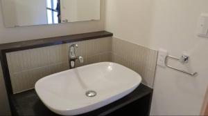 a white sink in a bathroom with a mirror at 尾上邸 日本遺産の一棟貸し 離島の宿 in Marugame