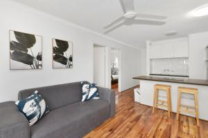 a living room with a couch and a kitchen at Allamanda Unit 22 in Long Jetty +2 photos