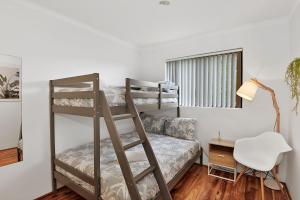 a bedroom with a bunk bed and a desk at Allamanda Unit 22 in Long Jetty