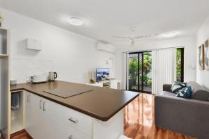 a kitchen with a table and a couch in a room at Allamanda Unit 22 in Long Jetty