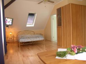 a bedroom with a bed and a table with flowers at Hotel Altes Gasthaus Düsterbeck in Emsdetten