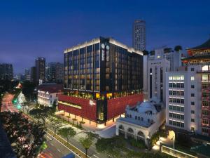 a large building in a city at night at Pullman Singapore Hill Street in Singapore