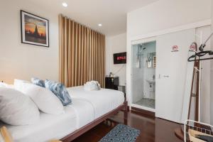 a bedroom with a bed with white pillows at An Ant House in Bangkok