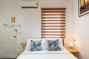 a bedroom with a bed with blue and white pillows at An Ant House in Bangkok