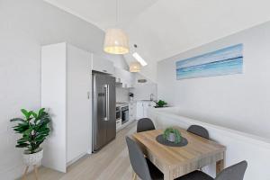 a kitchen and dining room with a table and a refrigerator at Pacific Breeze 11 in Blue Bay 
