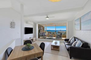a living room with a couch and a table at Pacific Breeze 11 in Blue Bay 