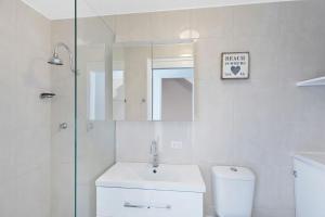 a white bathroom with a sink and a shower at Pacific Breeze 11 in Blue Bay  +7 photos