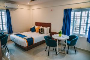 a bedroom with a bed and a table and chairs at Keerthis Elite Hotel near Kempegowda international airport in Bangalore +31 photos