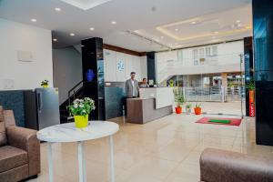a man standing in the lobby of a building at Keerthis Elite Hotel near Kempegowda international airport in Bangalore