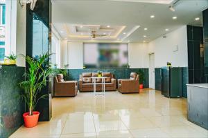 a lobby with couches and a screen in a building at Keerthis Elite Hotel near Kempegowda international airport in Bangalore