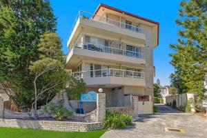 an apartment building with balconies and trees at Pacific Breeze 11 in Blue Bay 