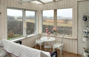 a porch with a table and chairs and a view of a field at 2 Bedroom Nice Home In Gedser in Gedser