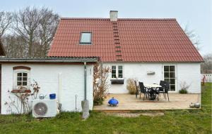 a white house with a wooden deck with a table at 2 Bedroom Nice Home In Gedser in Gedser