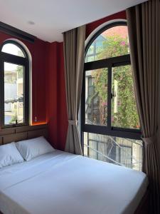 a bedroom with two windows and a white bed at Airport Homestay 2 in Danang +22 photos