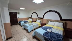 a bedroom with two beds and two tables at Hotel la Ermita in Las Victorias