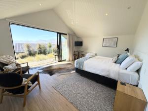 a bedroom with a bed and a large window at The Quarters Unit 2 - Lake Tekapo in Lake Tekapo