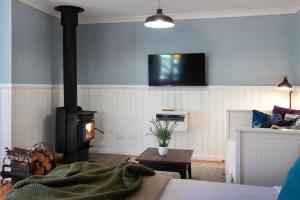 a living room with a fireplace and a stove at Oscars in Hepburn Springs