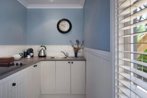 a kitchen with a sink and a clock on the wall at Oscars in Hepburn Springs