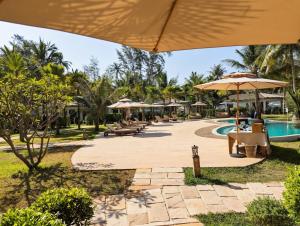 a pool at the resort with umbrellas and tables at Mint Lotus Resort - Koh Kood in Ban Bang Bao +37 photos
