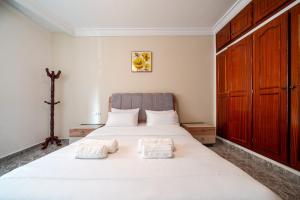 a bedroom with a large white bed with towels on it at Spacious Apartment 1 min from Beach in Tangier