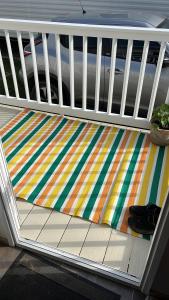 a bed with a colorful rug on a porch at Beach getaway in King's Lynn