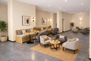 a lobby with couches and tables and chairs at Harmony Hotel in Vientiane