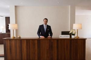 a man in a suit sitting at a desk at Harmony Hotel in Vientiane