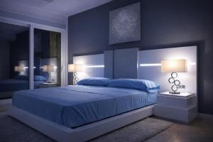 a blue bedroom with a large bed and two lamps at Casa Solaria Córdoba in Guadalcázar +42 photos