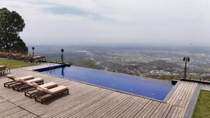 a swimming pool with lounge chairs on a wooden deck at The Belvedere Kasauli in Kasauli