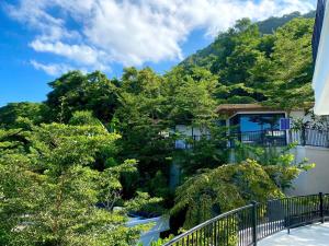 a building with trees in front of a mountain at Babylon Mini Resort in Vung Tau