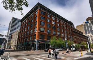 a group of people crossing a street in front of a building at The Elevated Gallery - Historic Loft - Heart of Downtown - 98WalkScore in Denver