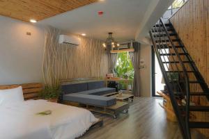 a bedroom with a staircase and a bed and a couch at Babylon Mini Resort in Vung Tau +23 photos