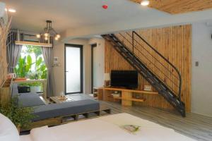 a living room with a couch and a staircase at Babylon Mini Resort in Vung Tau