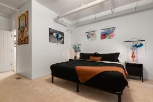 a bedroom with a bed and paintings on the wall at The Elevated Gallery - Historic Loft - Heart of Downtown - 98WalkScore in Denver