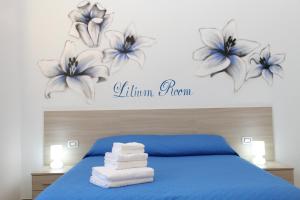 ナポリにあるB&B Flower's Houseのベッドルーム1室(花の壁に青いベッド1台付)