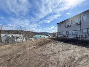an empty dirt road next to a building at たっこ宿 in Takko