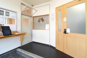 a room with a door and a desk with a computer at たっこ宿 in Takko