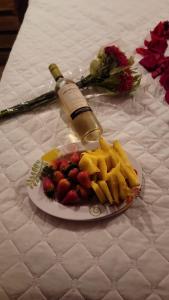 a plate of fruit on a table with a bottle of wine at Glamping Encanto Amazónico Macas in General Proaño