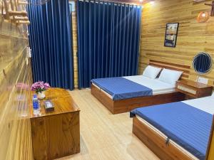 a room with two beds and a table with flowers at Huy Hùng Cô Tô in Nam Cap