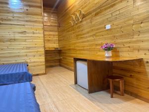 a room with a wooden wall with a table and a tv at Huy Hùng Cô Tô in Nam Cap
