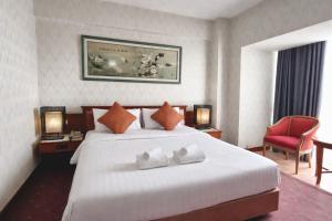 ein Hotelzimmer mit einem Bett und zwei Handtüchern in der Unterkunft Asian Hotel in Hat Yai + 7 Fotos