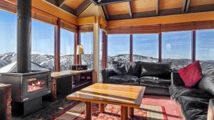 a living room with a couch and a fireplace at Gundanora Chalet in Mount Hotham