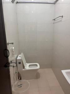 a white bathroom with a toilet and a sink at Du Auro Residency in Kuilapayam