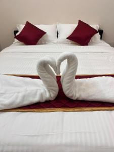 two swans shaped like hearts are sitting on a bed at Du Auro Residency in Kuilapayam