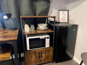 a microwave on a wooden shelf next to a refrigerator at Glenlyon Lodge - Gladstone in Gladstone