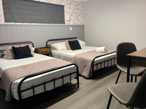 a room with two beds and a table and chairs at Glenlyon Lodge - Gladstone in Gladstone +48 photos