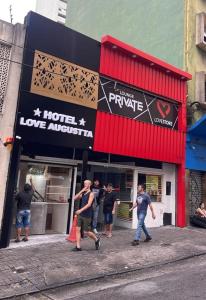 a group of people walking in front of a store at Hotel Love Augustta in São Paulo