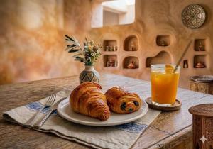 a table with a plate of croissants and a glass of orange juice at Spacious Apartment 1 min from Beach in Tangier +16 photos
