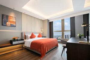 a bedroom with a bed and a desk and a window at Grand Madison Hotel Hangzhou in Hangzhou